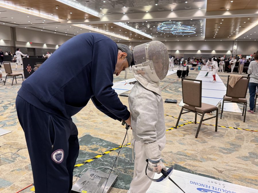 Coach Boris giving pre-bout instruction to young fencer at competition