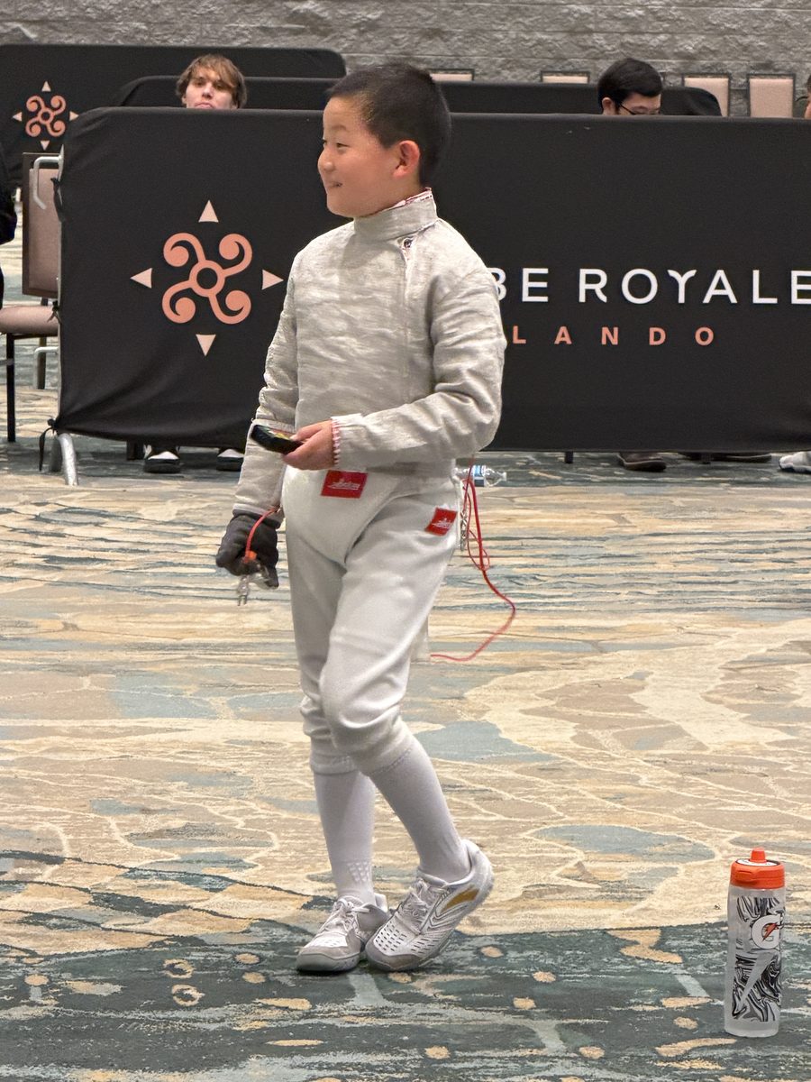 Young CSFA fencer walking at national fencing tournament